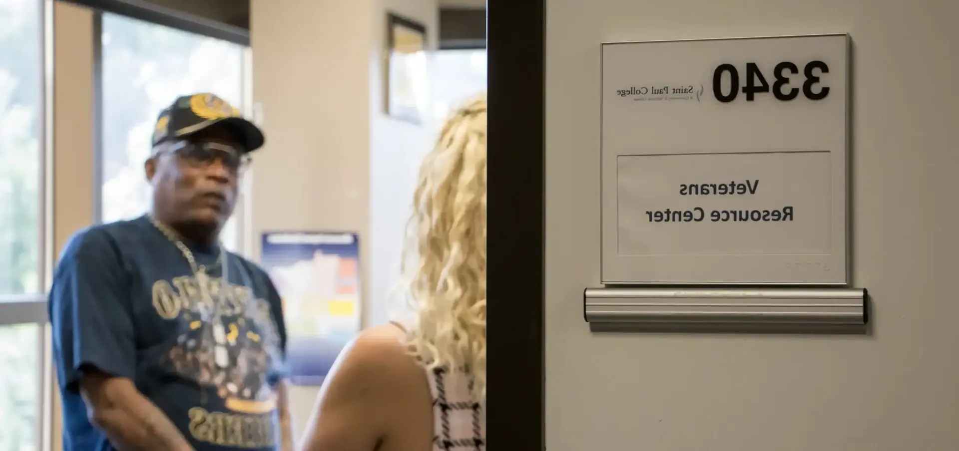 photo of students chatting in veterans center with sign on door reading 3340 Veterans Resource Center